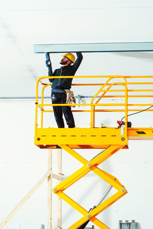 Worker at work in the construction of a plasterboard wall.